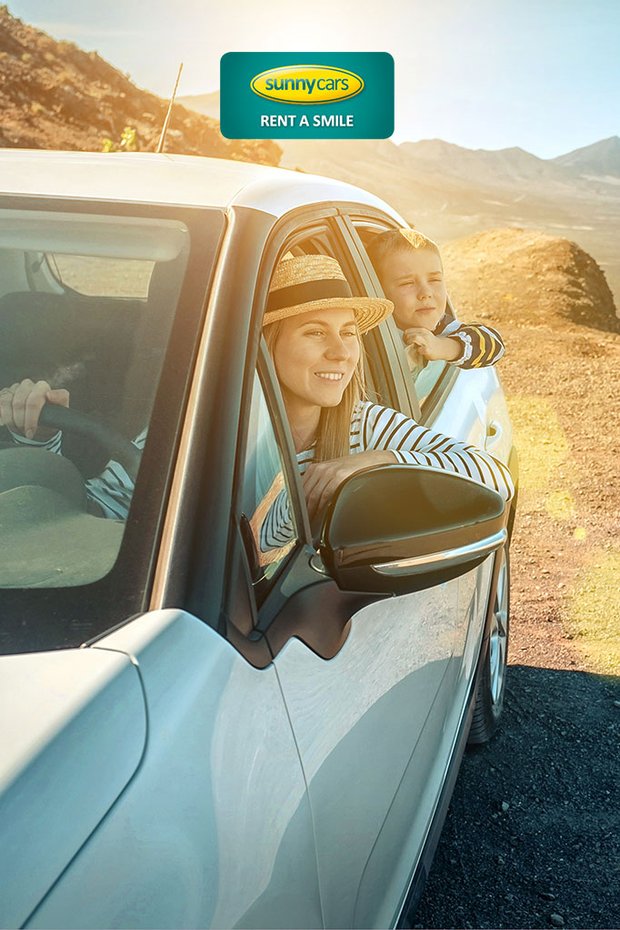 Mutter und Sohn sitzen in einem weißen Auto mit Blick auf das wunderschöne Meer.